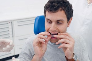 Invisalign patient placing aligner on his teeth