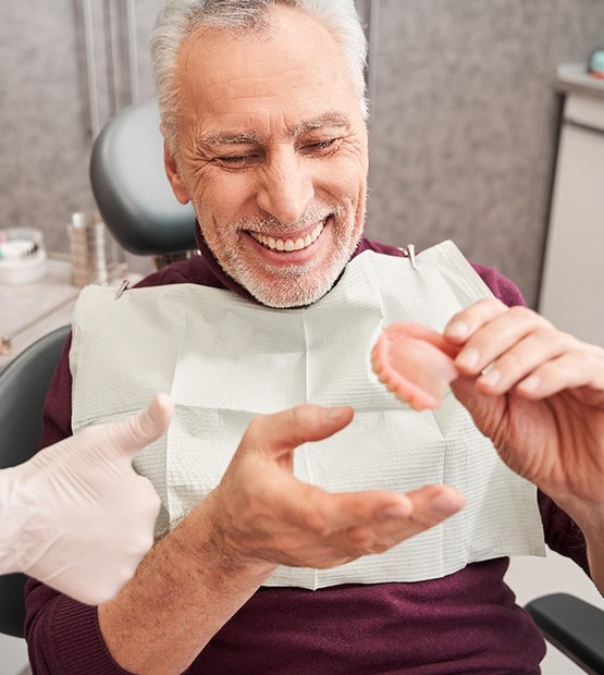 Dentist discussing dentures with male patient