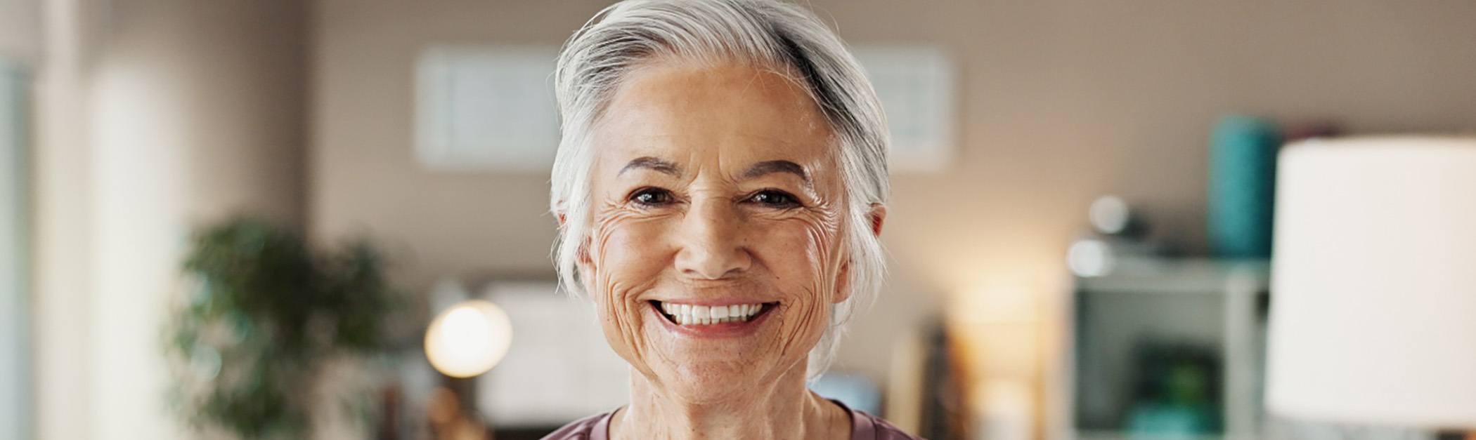 An older woman smiling after a visit with her Aetna dentist in Encino