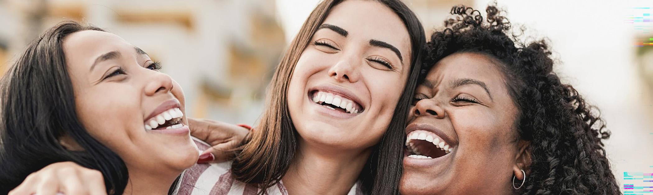 Three women laughing and smiling confidently because of a BlueCross BlueShield dentist in Encino