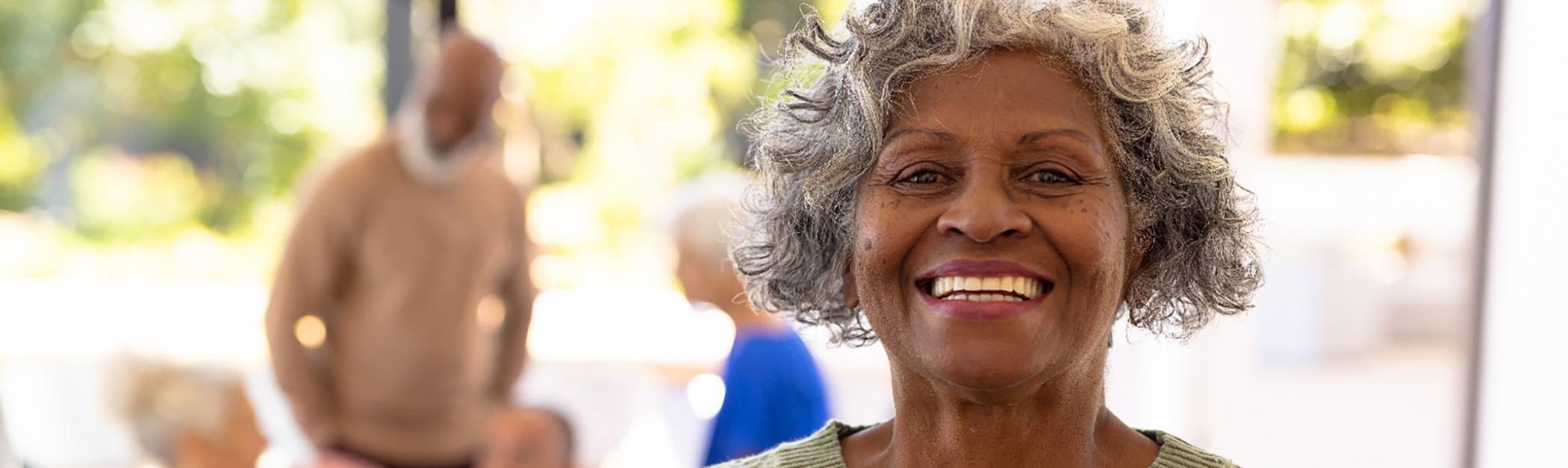 Older woman smiling among friends after her visit to the Cigna dentist in Encino
