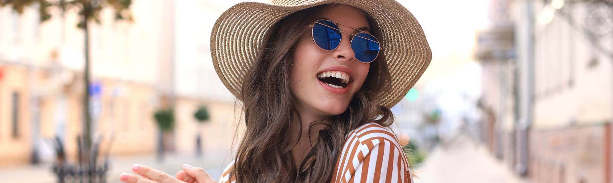 Woman in large hat smiling outside after a visit with her Delta Dental dentist in Encino