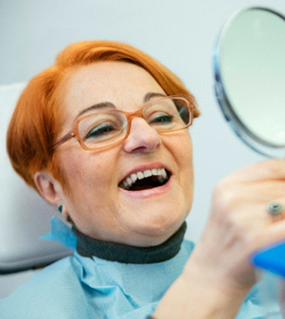 A woman looking at her newly restored smile