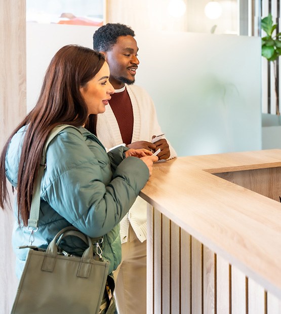 Couple talking to front desk staff about payment