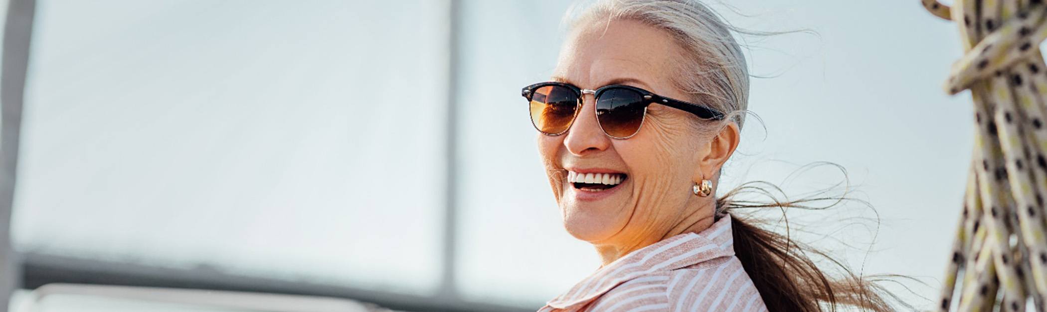 Older woman on a boat and smiling after visiting a MetLife dentist in Encino 