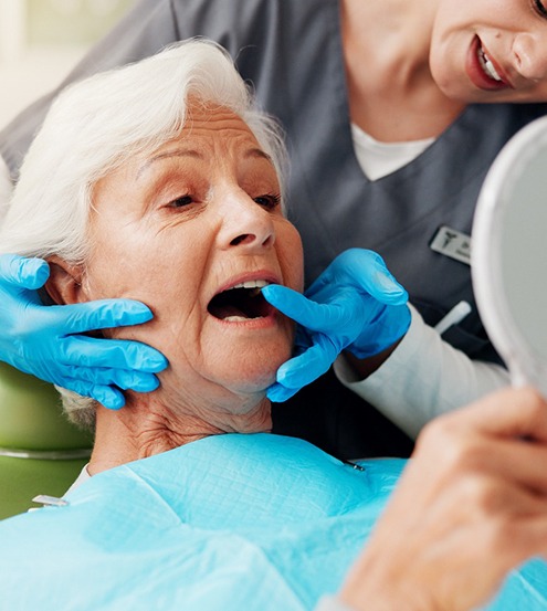 Dentist showing older woman her new tooth