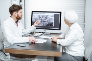 older woman listening to her dentist explain dental implants