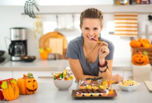 Woman eating Halloween treats and smiling