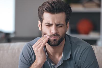 Man holding his jaw in pain, encino ca