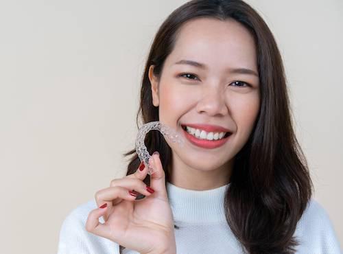 Asian woman holding invisalign clear aligner, encino ca