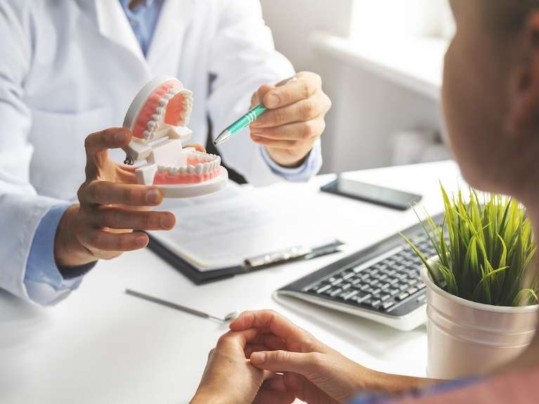 Dentist pointing to a set of teeth, encino ca