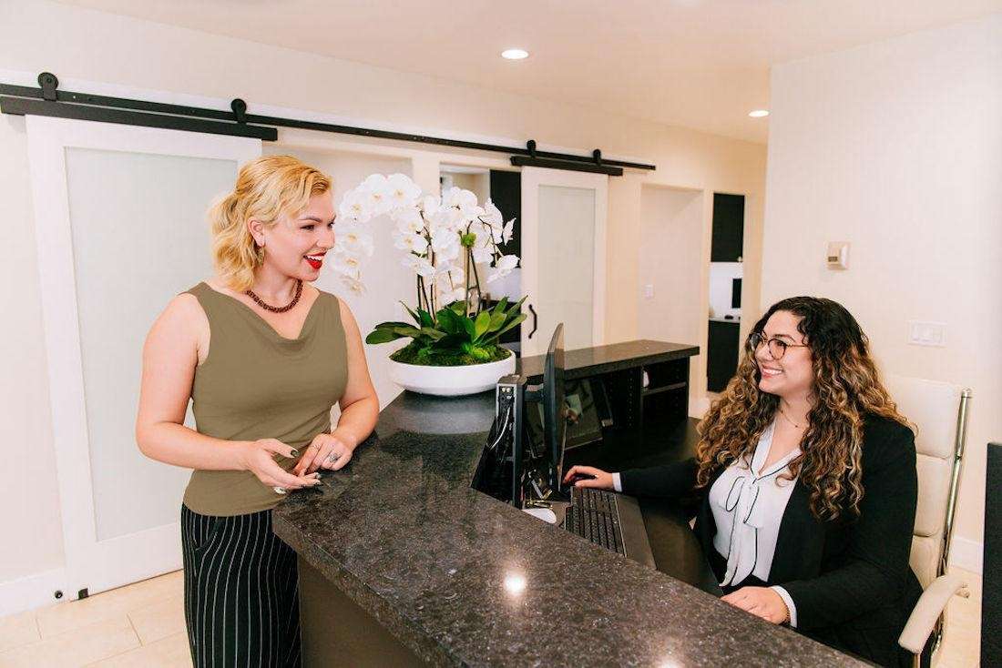 Patient smiling at front desk of signature smiles, encino ca